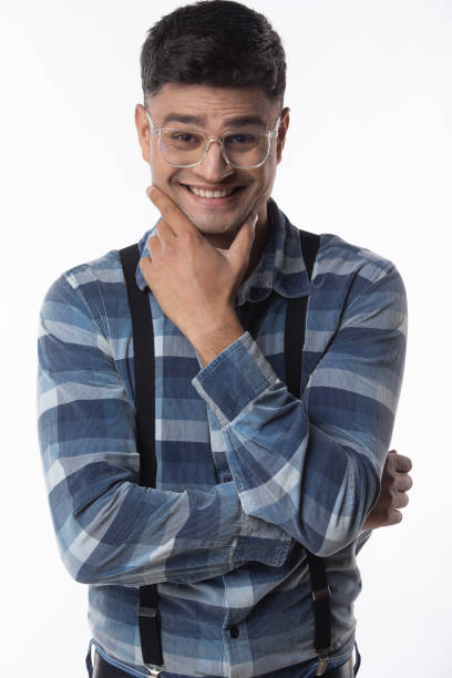 Portrait of smiling handsome entrepreneur in eyeglasses and with hand on chin standing against white background