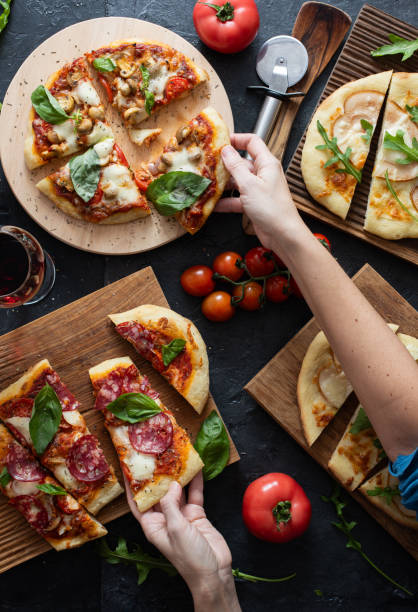istock Women's hands hold slices of pizza 2204915134