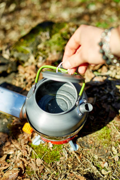 istock Boiling water in a camping kettle over a portable stove in a serene forest setting during daylight hours 2204916458
