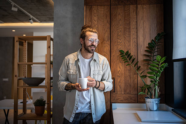 istock Young man enjoying a cup of coffee in his modern apartment kitchen 2204916523