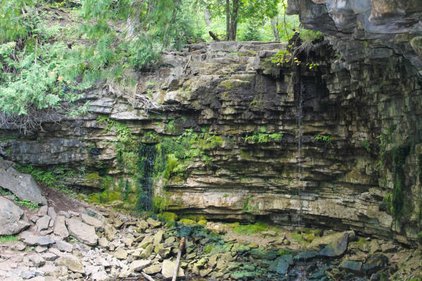 istock Hilton Falls cliff face showing layered limestone rock formation with small trickling waterfalls and moss-covered surfaces 2204917002
