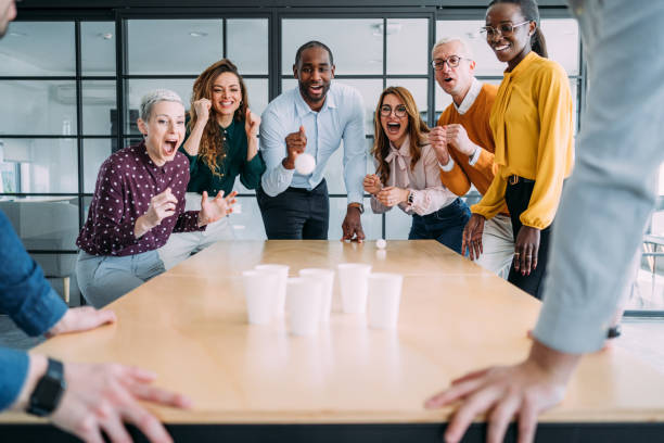 istock Young colleagues playing beer pong in the office. 2204917957