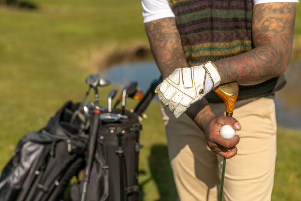Hand in golf glove puts ball on golf tee. Focusing attention while playing golf concept