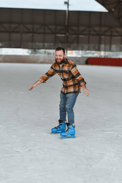 istock Joyful Male Having Fun on Ice Rink Smiling While Trying Out Skating for First Time 2204918295