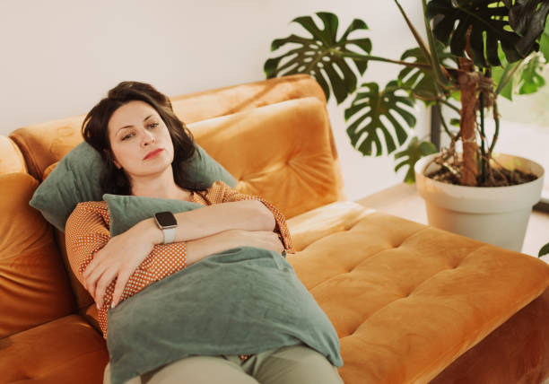 istock Relaxed Woman Resting on Cozy Couch in a Modern Living Room Setting 2204918450