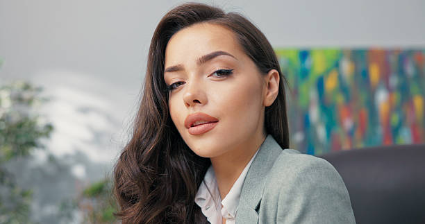 istock The stylish accounting worker or secretary in the office completes her tasks, shuts down her laptop, and looks into the camera with a calm and professional smile. 2204919617
