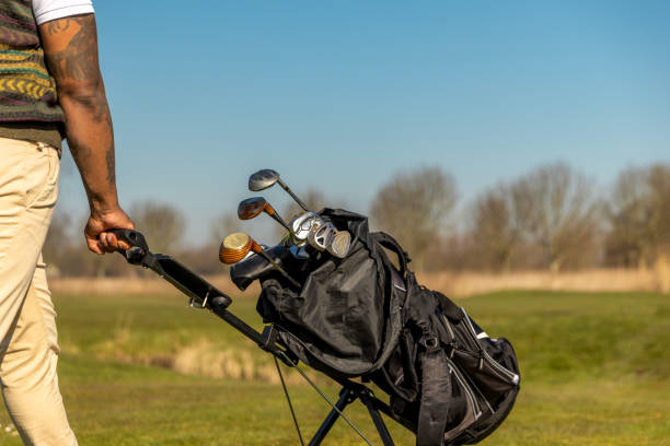 Unknown black golfer man enjoying a day of activity on a public golf course in the Netherlands