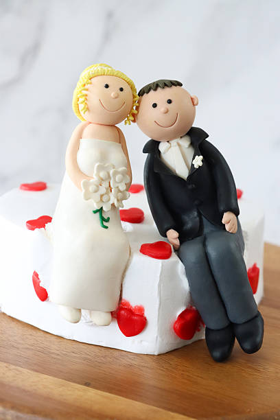 istock Image of romantic heart-shaped wedding cake featuring fondant icing and elegant bride and groom figurines, celebration of love 2204923813
