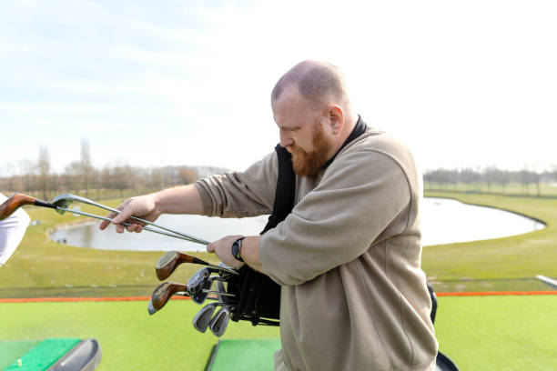 istock Senior redhead man at a golf driving range 2204924686