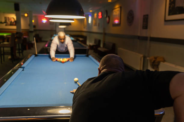 Stylish senior black man playing pool in a public bar
