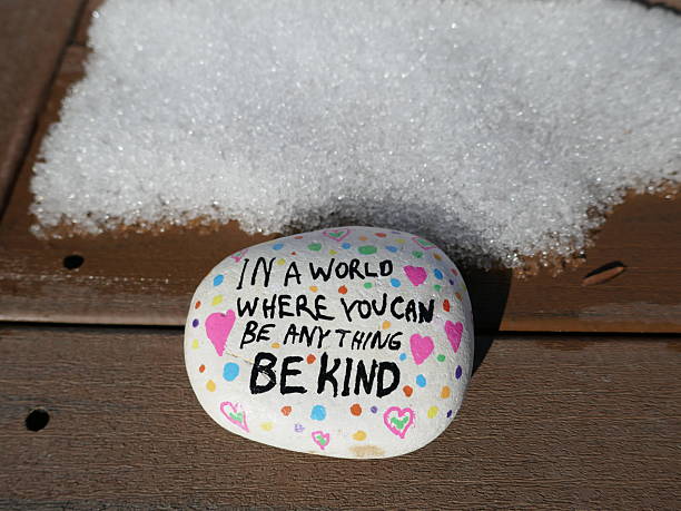 istock Winter snow patch on board with be kind kindness rock 2204928060