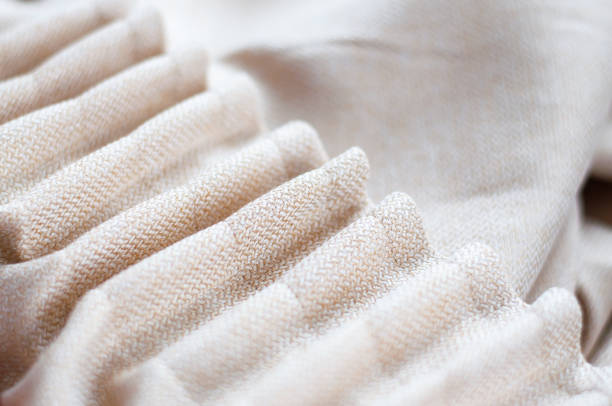 Collected beige curtain, folds on the curtain. Curtains in beige which are going to hang on the window.