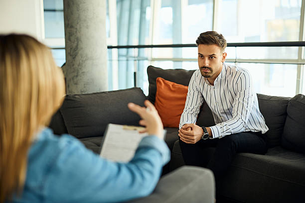 istock Man Engaged in Conversation During a Professional Counseling Session in Modern Setting 2204931380