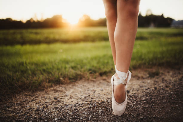 Female ballerina en pointe with laced slippers outdoors with copy space