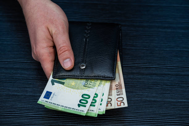 istock man handing wallet with euro and count money, saving concept 2204937604