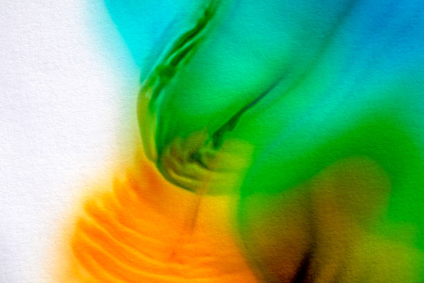 Colorful texture on paper with flowing liquid paint with green and orange color perfect for backgrounds and textures