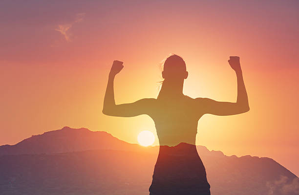 istock Silhouette of strong woman flexing her muscles. 2204943806