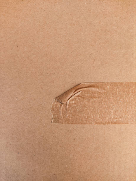 istock Brown packaging tape peeling from cardboard box in prague 2204944712