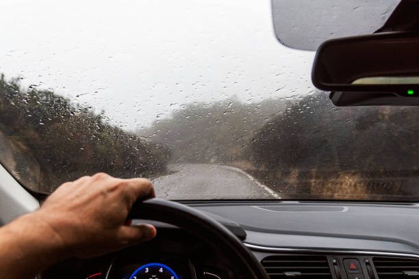 istock Car windshield covered in raindrops due to heavy rain, seen from the driver's position. 2204946970