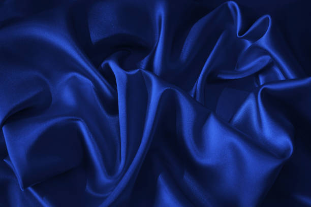 Black dark blue abstract background. Silk satin fabric. Silky shine glitter. Soft folds draped. Beautiful elegant luxury festive romantic christmas.
