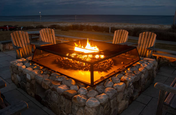 istock Adirondack Chairs around a Fire Place Near the Beach 2204958295