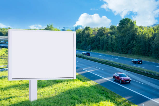 istock blank billboard on with copy space for text or content, mockup blank billboard, road, multi-lane highway with car traffic with green trees, bird's-eye view, Space for your ad 2204958475
