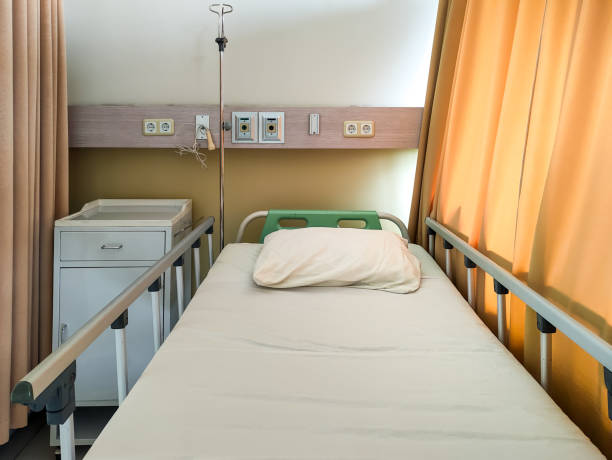 istock Modern Hospital Bed in Room with IV Stand and Side Table 2204961034