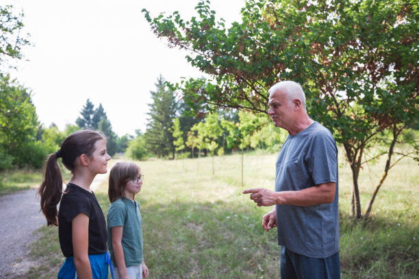 Grandfather and grandsons talking outdoors