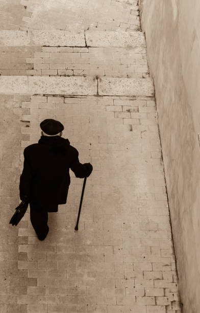 Retro classic business fashion man wearing white striped suit and hat. Standing with cane. Studio shot.