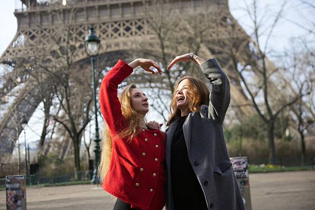 istock Two women making heart shape in front of Eiffel Tower 2204967225