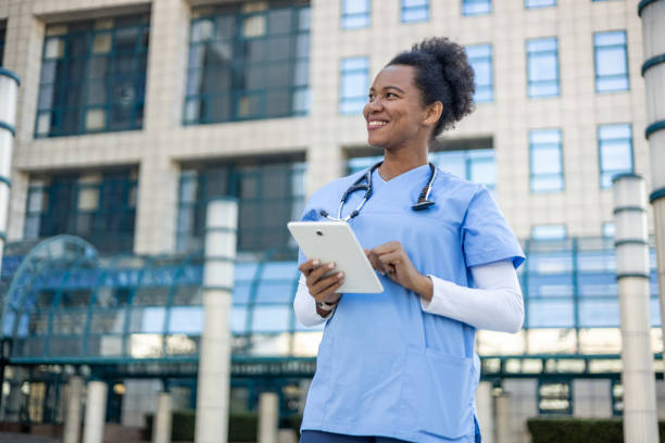 istock Confident doctor using digital tablet outside hospital building 2204970631