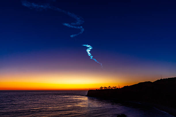 The spectacular launch of the SpaceX Falcon 9 rocket from Vandenberg Air Force Base streaks across the evening sky over Palos Verdes, illuminating the horizon with a brilliant trail of light as onlookers marvel at the powerful display of modern space technology against the backdrop of the serene California coastline.