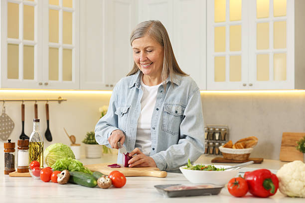 istock Happy woman cutting onion at table in kitchen 2204972130