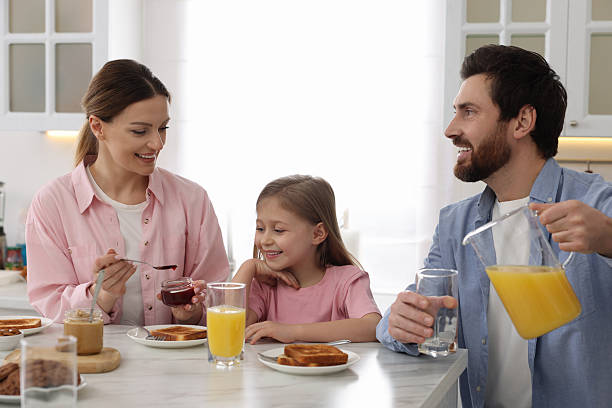 istock Happy family having breakfast at table in kitchen 2204972217
