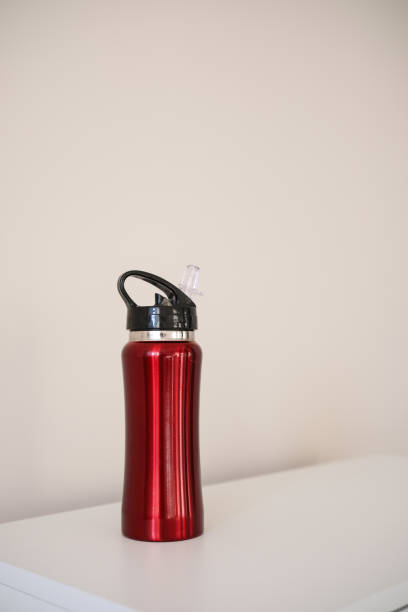 This is a sleek, vibrant red water bottle equipped with a black cap, ideal for staying hydrated while walking.