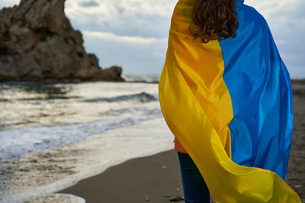 istock Waving a Vibrant Ukranian Flag by the Shore During a Cloudy Afternoon, Expressing Unity and Hope for a Brighter Future 2204976106