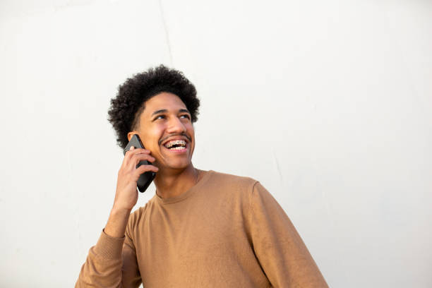 istock smiling young african american man talking with mobile phone 2204976311