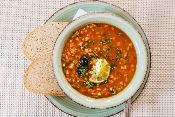 istock Homemade solyanka soup with lemon and herbs in a plate. 2204977990