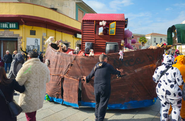 Maracalagonis, Sardinia, Italy, March 2, 2025. For the city Carnival, a big party with allegorical floats, themed groups and masks. In the foreground the float, which depicts Noah's Ark with many stuffed animals, prepares for the parade among a colorful crowd of participants in costume and onlookers.