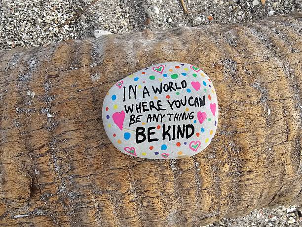 istock Be kind kindness rock on fallen tropical tree trunk 2204983613