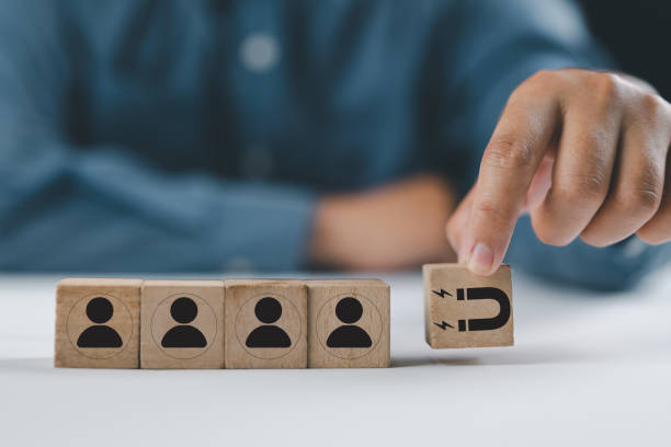 istock Customer retention concept. Inbound marketing strategy. Attracting potential customers. Hand puts wooden cubes with magnet attracts customer icons on beautiful grey background and copy space. Loyalty 2204984990