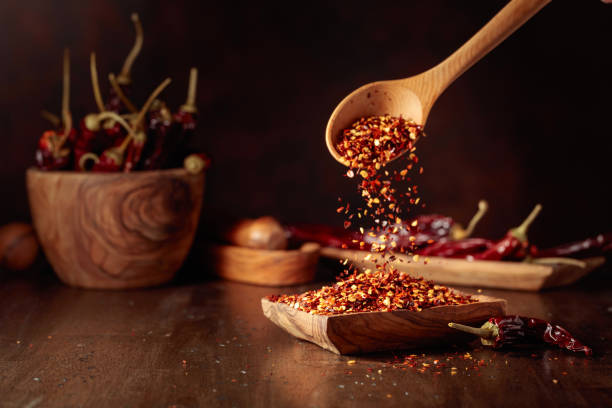 istock Chilli flakes are poured into a wooden dish. 2204986968
