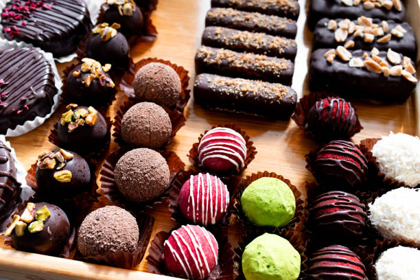 istock Assorted gourmet chocolate truffles with nuts and toppings on display 2204987980