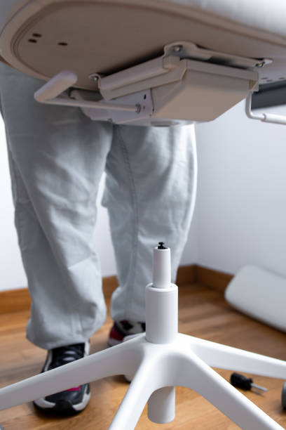 istock Man assembling office chair base in room with wooden floor 2204988813