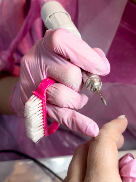 istock Professional manicure process with pink gloves and nail drill on client hand 2204988817