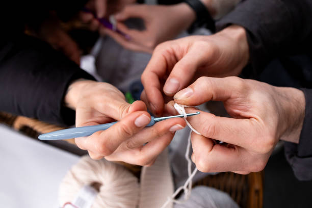 istock Close up of hands crocheting yarn with blue hook and white thread 2204988831