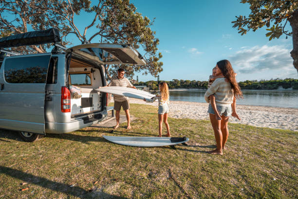 istock Father Unloading Surfboards During Family Beach Camping Trip 2204989290