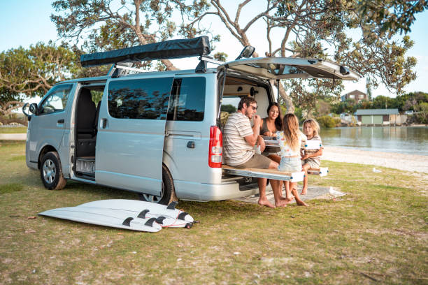 istock Family Enjoying Meal at Minivan Table Near Seaside Park Setting 2204989294
