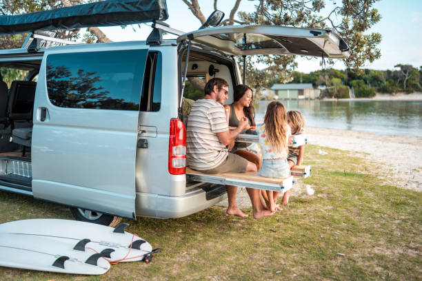 istock Family Enjoying Outdoor Meal on Minivan Dining Table 2204989295