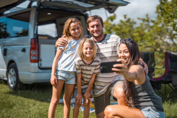 istock Smiling Family Posing Outdoors for a Camping Selfie 2204989441